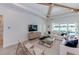 Bright living room featuring wood beam ceiling and sliding glass doors leading to pool at 10388 Sun Isle Dr, Englewood, FL 34223