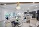 Open living room and kitchen with white sofas, countertops, and stainless steel appliances at 10388 Sun Isle Dr, Englewood, FL 34223