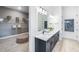 Main bathroom view with a walk-in closet featuring custom shelving and a tufted ottoman at 10388 Sun Isle Dr, Englewood, FL 34223
