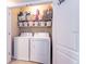This laundry room features a full-sized washer, dryer, and shelving for ample storage of supplies and linens at 10425 Yellow Spice Ct, Riverview, FL 33578