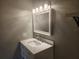 Bathroom vanity featuring a white countertop, and a decorative mirror with vanity lights at 11715 Salmon Dr, Port Richey, FL 34668