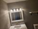 Bathroom vanity featuring a white countertop, a decorative mirror with vanity lights, and toilet at 11715 Salmon Dr, Port Richey, FL 34668