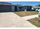 Single-story home featuring a driveway, manicured lawn, and solar panels at 11715 Salmon Dr, Port Richey, FL 34668