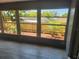 View of the backyard from the screened-in lanai with tiled floors and multiple windows at 11715 Salmon Dr, Port Richey, FL 34668