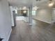 Open-concept living area with modern kitchen, stone fireplace, and wood-look flooring at 11715 Salmon Dr, Port Richey, FL 34668
