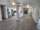 Spacious open-concept living area with modern kitchen, stone fireplace, and wood-look flooring at 11715 Salmon Dr, Port Richey, FL 34668