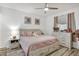 Serene bedroom with soft pink bedding, wood-look flooring, and a dresser with a mirror at 13215 Beechberry Dr, Riverview, FL 33579