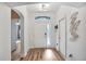 Bright entryway featuring hardwood floors, white walls, and decorative leaf art, creating a welcoming ambiance at 13215 Beechberry Dr, Riverview, FL 33579