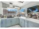 Bright, updated kitchen featuring blue cabinets, gas cooktop, and pass-through window to a cozy outdoor patio at 13215 Beechberry Dr, Riverview, FL 33579
