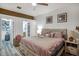 Comfortable main bedroom with neutral walls, wood-look floors, a ceiling fan, and a view to the ensuite bathroom at 13215 Beechberry Dr, Riverview, FL 33579