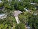 Aerial view of the property showcases the lush greenery, mature trees, and charming neighborhood surrounding the home at 1431 Normandy Ln, Palm Harbor, FL 34683
