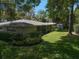 Beautiful home exterior with a large backyard, featuring a storage shed and mature trees with lots of shade at 1431 Normandy Ln, Palm Harbor, FL 34683