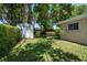This backyard features a storage shed, green grass, and lush greenery making this the perfect storage or lawn care space at 1431 Normandy Ln, Palm Harbor, FL 34683