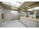 Modern bathroom with dual sinks, a large mirror, and a glass block partition at 1431 Normandy Ln, Palm Harbor, FL 34683
