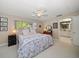 Bright bedroom featuring a ceiling fan, window views, and adjacent bathroom access at 1431 Normandy Ln, Palm Harbor, FL 34683