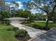 Charming home features a well-manicured lawn, long driveway, mature trees, and classic mailbox at 1431 Normandy Ln, Palm Harbor, FL 34683