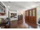 Inviting foyer with hardwood floors, stained glass double doors, and a glimpse into the living room with a stone fireplace at 1431 Normandy Ln, Palm Harbor, FL 34683