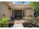 Beautiful front door entrance flanked by decorative plants and lighting fixtures at 1431 Normandy Ln, Palm Harbor, FL 34683