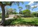 Charming single-story home with a lush front lawn and mature trees at 1431 Normandy Ln, Palm Harbor, FL 34683