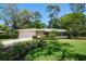 Charming single-story home with a lush front lawn and mature trees at 1431 Normandy Ln, Palm Harbor, FL 34683