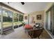 Screened in porch with neutral tile, framed wall art, and comfortable seating overlooking the manicured backyard at 1431 Normandy Ln, Palm Harbor, FL 34683