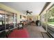 Spacious screened patio with ceiling fan, bar access to the kitchen, grill, and cushioned seating area at 1431 Normandy Ln, Palm Harbor, FL 34683