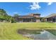 Backyard view featuring screened lanai and pond, blending indoor/outdoor living at 14421 Swiss Bridge Dr, Lithia, FL 33547