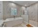Modern bathroom features a free-standing tub, walk-in shower, and marble tile at 14421 Swiss Bridge Dr, Lithia, FL 33547