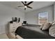 This bedroom has light grey walls, a ceiling fan, dresser, computer desk, and a full bed at 14421 Swiss Bridge Dr, Lithia, FL 33547