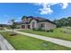Well-maintained two-story home featuring a tile roof, stone accents, and manicured landscaping at 14421 Swiss Bridge Dr, Lithia, FL 33547