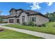 Well-maintained two-story home featuring a tile roof, stone accents, and manicured landscaping at 14421 Swiss Bridge Dr, Lithia, FL 33547