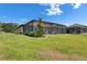Well-maintained exterior view of the house with a screened lanai, overlooking the green lawn at 14421 Swiss Bridge Dr, Lithia, FL 33547