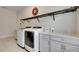 Well-equipped laundry room with modern washer and dryer, alongside sleek cabinetry and ample counter space at 14421 Swiss Bridge Dr, Lithia, FL 33547