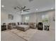 Spacious living room with a sectional sofa, modern ceiling fan, and white brick accent wall at 14421 Swiss Bridge Dr, Lithia, FL 33547