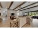Spacious living room with exposed beams, stone accent wall, and sliding doors to outdoor living space at 14421 Swiss Bridge Dr, Lithia, FL 33547