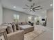 Bright living room featuring a large sectional sofa, statement ceiling fan, and comfortable seating at 14421 Swiss Bridge Dr, Lithia, FL 33547