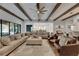 Open-concept living space featuring a large sectional sofa, hardwood floors, and exposed wood beams at 14421 Swiss Bridge Dr, Lithia, FL 33547