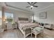Charming main bedroom featuring a ceiling fan, tray ceiling, and two large windows at 14421 Swiss Bridge Dr, Lithia, FL 33547