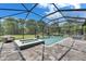 This backyard has a screened-in pool, spa, patio seating, and a view of the backyard at 14421 Swiss Bridge Dr, Lithia, FL 33547