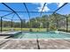 Stunning screened pool featuring a spa, tiled accents, and serene views of the lush backyard and pond at 14421 Swiss Bridge Dr, Lithia, FL 33547
