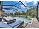 Relaxing screened pool area with comfortable lounge chairs, overlooking the backyard and beautiful landscaping at 14421 Swiss Bridge Dr, Lithia, FL 33547