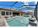 This backyard features a screened-in pool, spa, fountain, patio seating, and manicured landscaping at 14421 Swiss Bridge Dr, Lithia, FL 33547