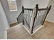 Modern staircase with dark wood railing and light wood flooring exudes elegance and provides a stylish transition at 14421 Swiss Bridge Dr, Lithia, FL 33547