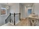 Bright stairway landing boasts modern chandelier, wood floors, and stylish decor, enhancing the home's appeal at 14421 Swiss Bridge Dr, Lithia, FL 33547