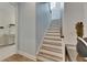 Bright stairway with wooden handrail showcases modern design and leads to upper levels with abundant natural light at 14421 Swiss Bridge Dr, Lithia, FL 33547