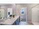 Bright bathroom featuring a double sink vanity with granite countertops, large mirror, and tile flooring at 1462 Brown Mallet Pl, Ruskin, FL 33570
