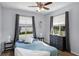Bright bedroom with hardwood floors, ceiling fan, two windows and neutral walls at 1601 Fluorshire Dr, Brandon, FL 33511