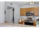 Fully-equipped kitchen featuring stainless steel appliances, wooden cabinets, and a laundry room at 1601 Fluorshire Dr, Brandon, FL 33511
