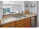 A kitchen with stainless steel appliances, wooden cabinets, and views to the dining room at 1601 Fluorshire Dr, Brandon, FL 33511