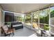 Relaxing screened porch with a bench and comfortable chair, offering serene views of the lush backyard at 1601 Fluorshire Dr, Brandon, FL 33511